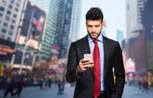 Businessman holding mobile smartphone using app texting sms message