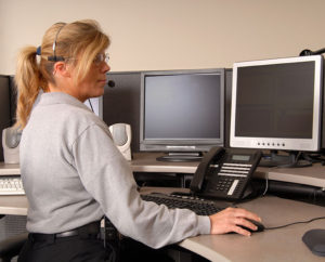 A police dispatcher working at console