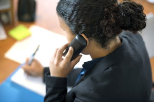 Receptionist Using Phone In Office